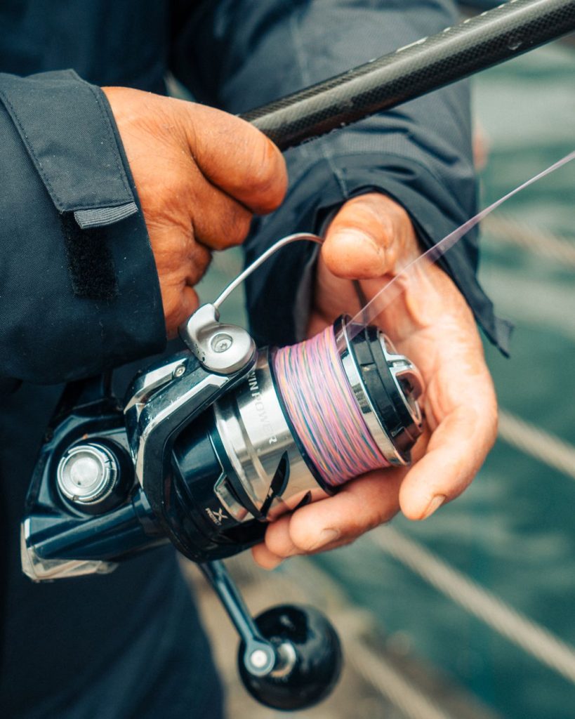 close up of angler s hands with fishing reel