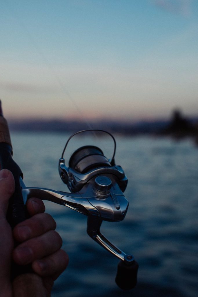 close up of fishing rod at dawn by lake